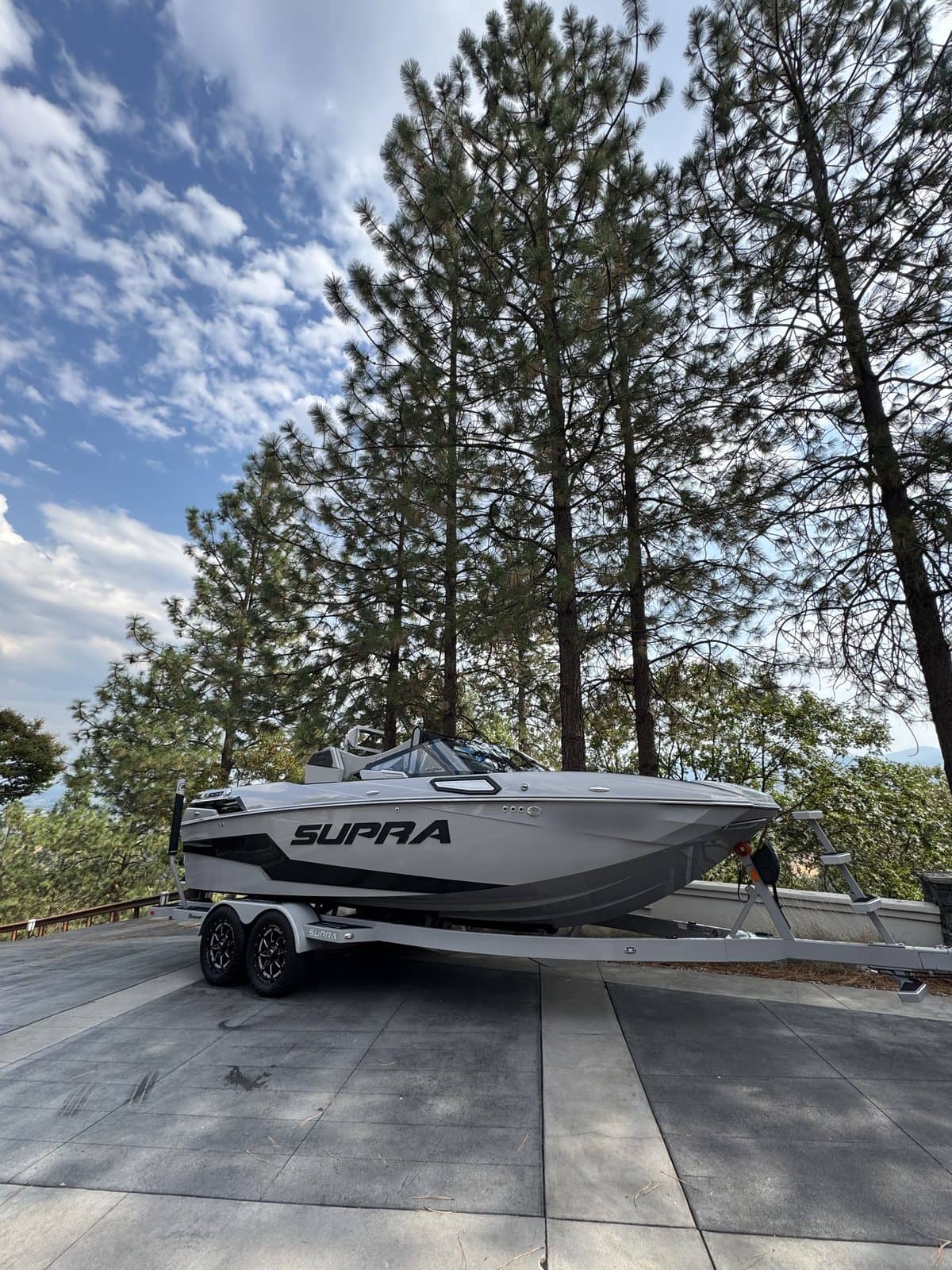 Detailed white and black ski boat sitting on its trailer.