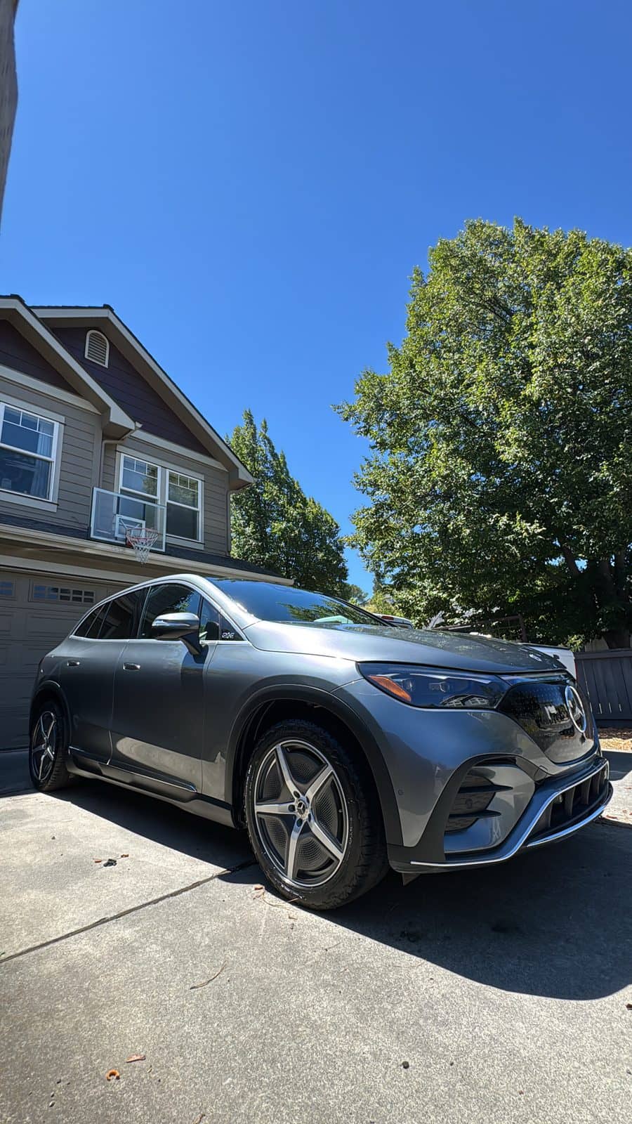 Silver SUV detailed in a sunlit residential driveway.